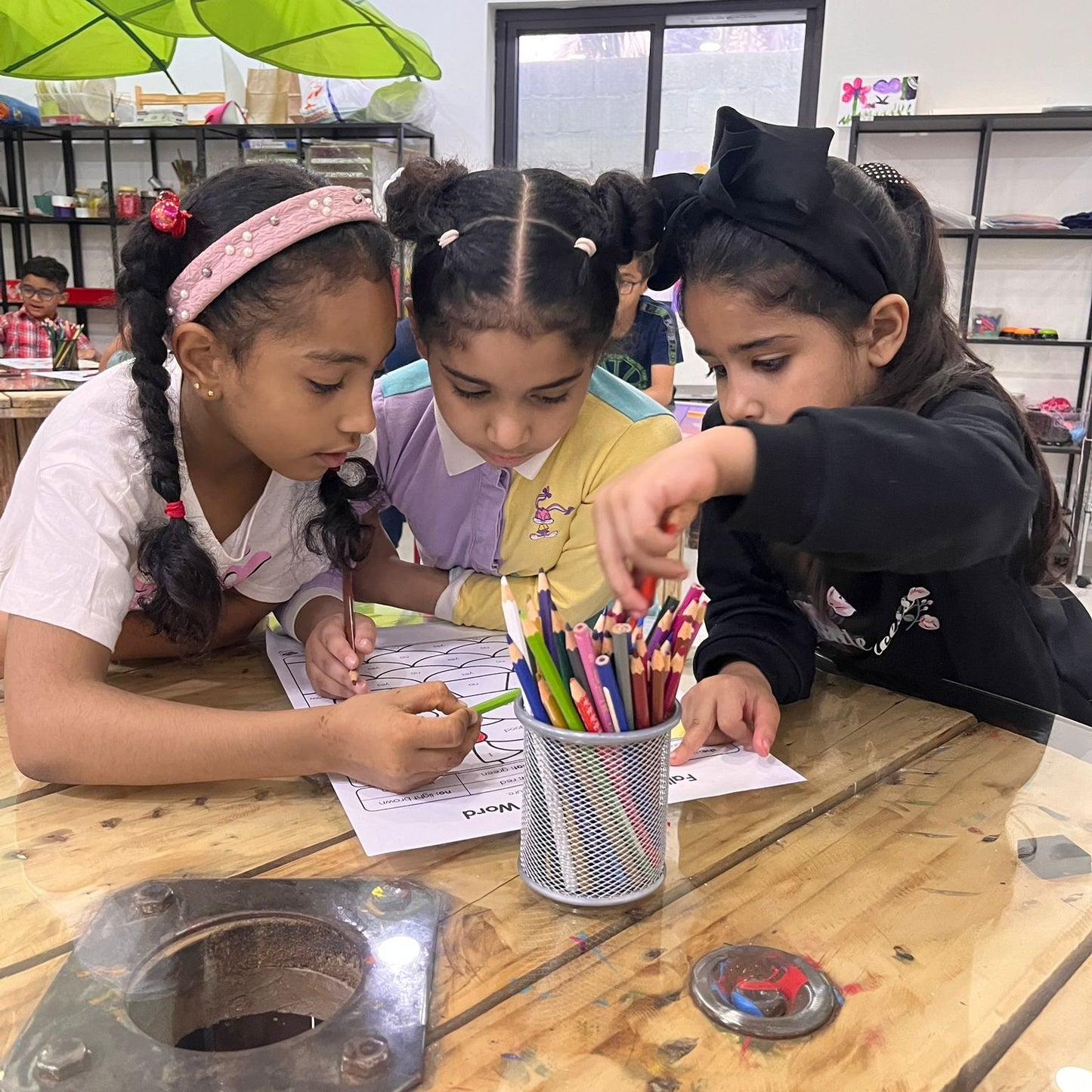 3 primary school students working together to read English