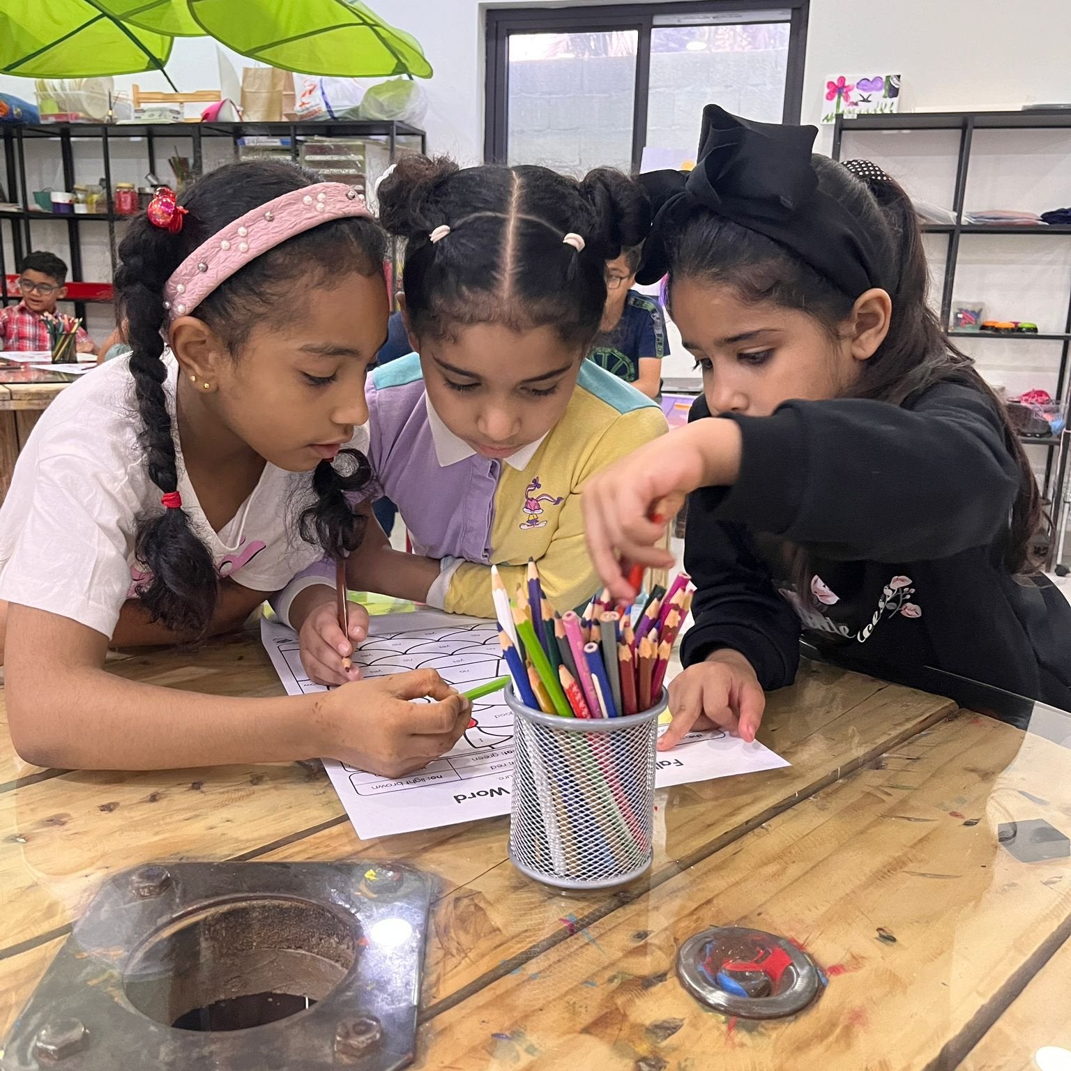 3 primary school students working together to read English